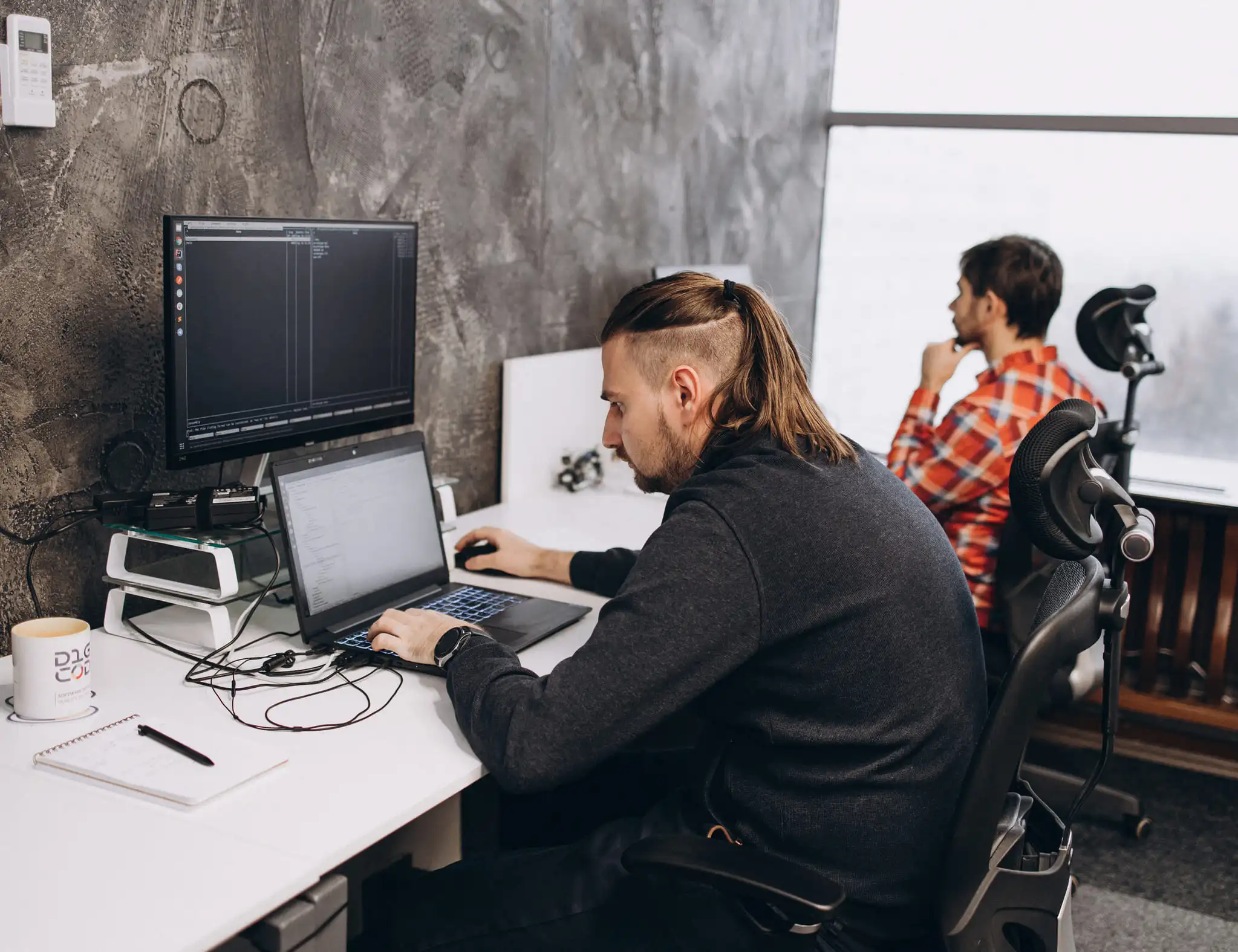 Two developers with laptops during work